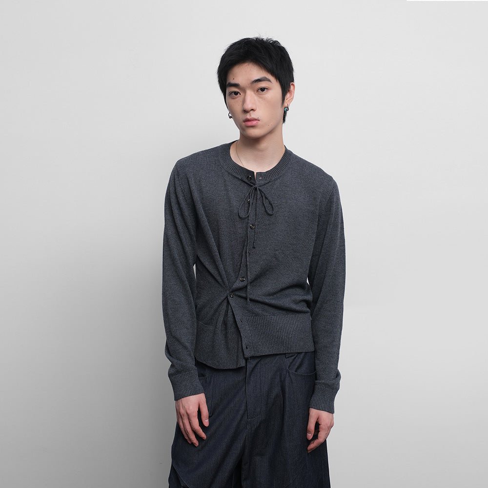 Ribbon knitted wool sweater with misplaced buttons and pleats